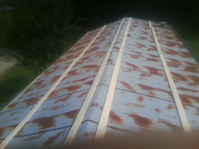 Rusted metal roof panels with new wood purlins before replacement — Storm Damage Roof Repair in Amagansett by Roofing Brothers