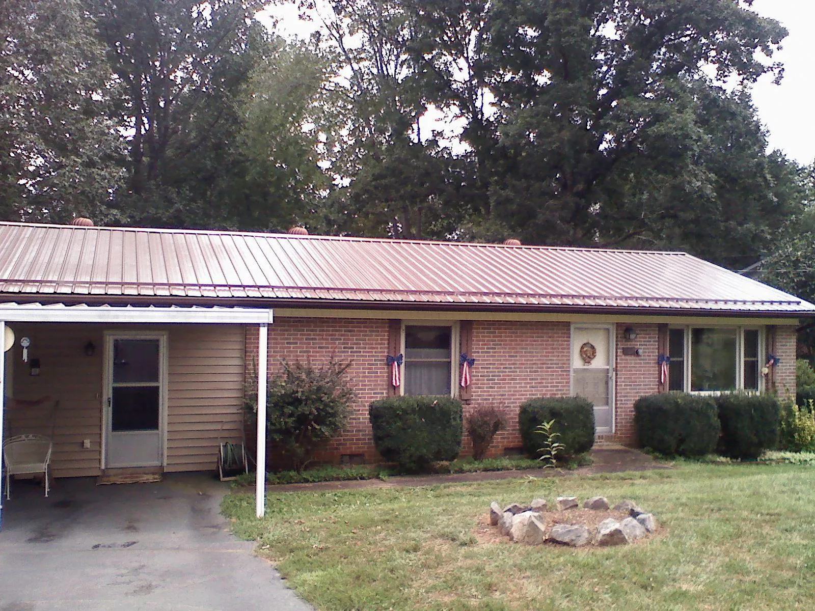 Bronze metal roof and carport on a brick ranch home — Roof Repair work by our crew in Amagansett